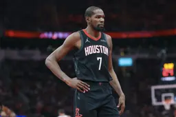 Kevin Durant en tenue des Houston Rockets, debout sur le parquet avec les mains sur les hanches lors d’un match NBA.